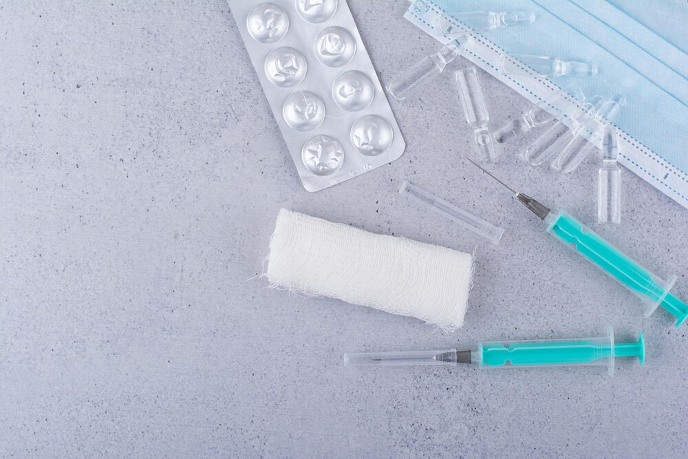 Mask, ampoules, syringes and medical pills on marble background. High quality photo